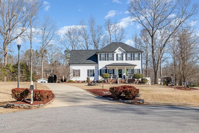 view of front of property with concrete driveway, a porch, and a shingled roof