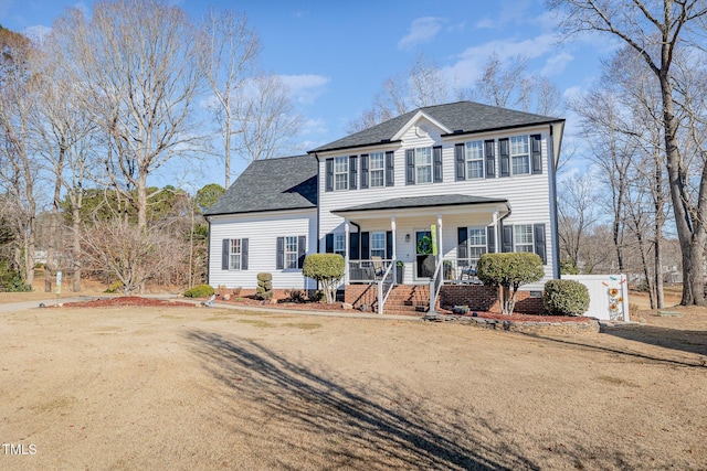 colonial house with covered porch, a shingled roof, and crawl space