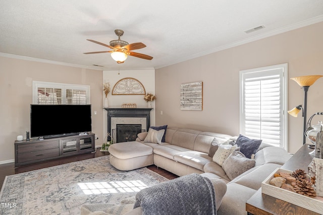 living area with ornamental molding, a high end fireplace, and wood finished floors