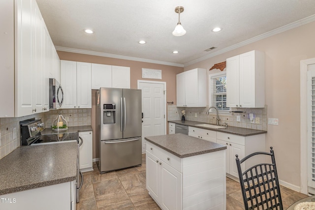 kitchen featuring stainless steel appliances, dark countertops, white cabinetry, and a sink