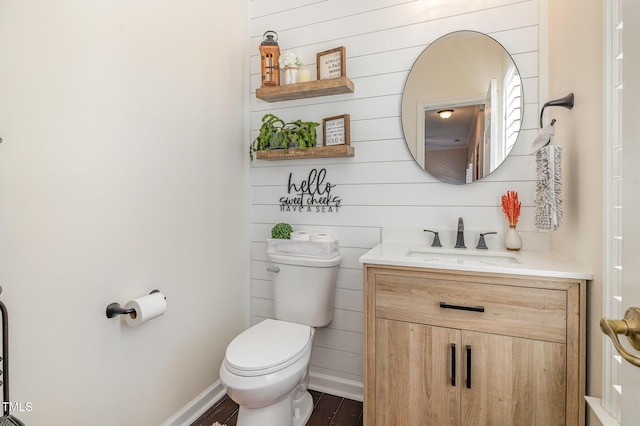 bathroom featuring wood finished floors, vanity, toilet, and baseboards