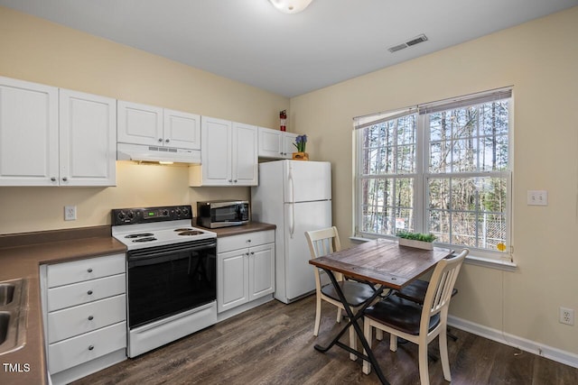 kitchen with electric stove, stainless steel microwave, visible vents, freestanding refrigerator, and under cabinet range hood