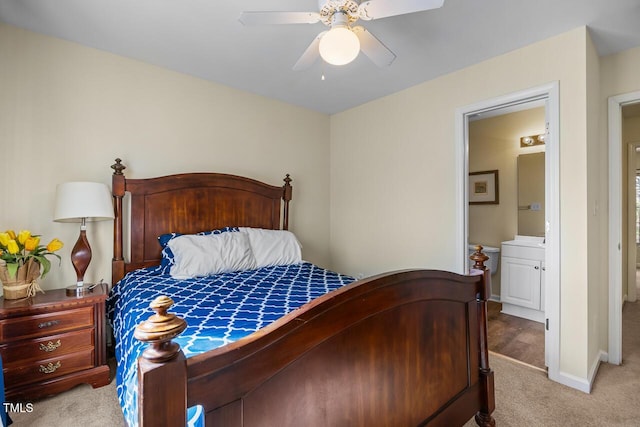 bedroom featuring light carpet, baseboards, a ceiling fan, and ensuite bathroom