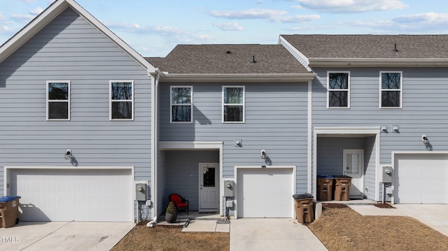 view of property with concrete driveway and roof with shingles