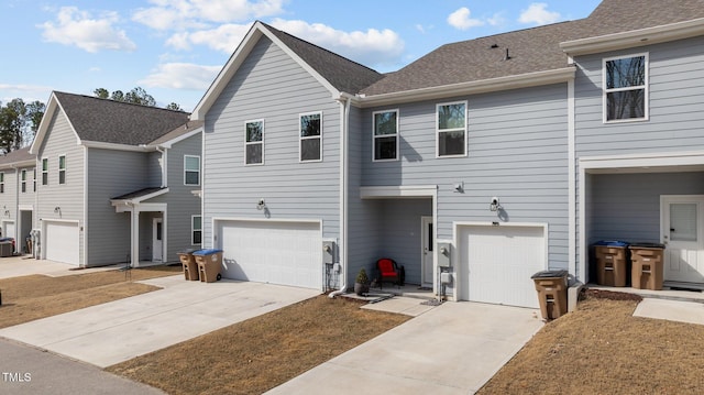 view of front of house with a garage, roof with shingles, and driveway