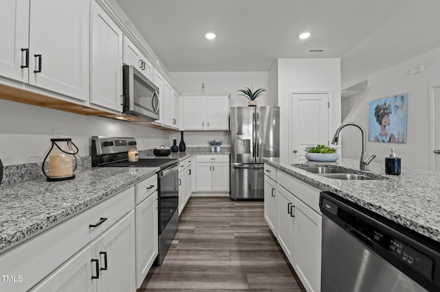 kitchen with a sink, visible vents, white cabinets, appliances with stainless steel finishes, and dark wood-style floors