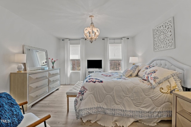 bedroom with a notable chandelier and light wood-style flooring