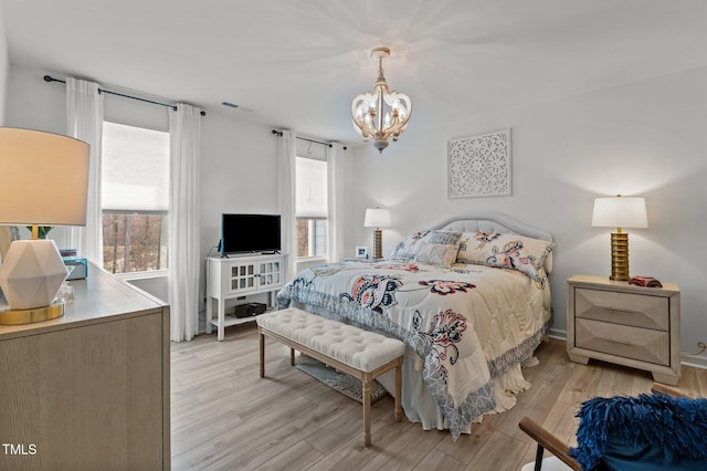 bedroom featuring light wood finished floors, multiple windows, and visible vents