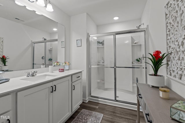 full bathroom featuring a stall shower, vanity, and wood finished floors