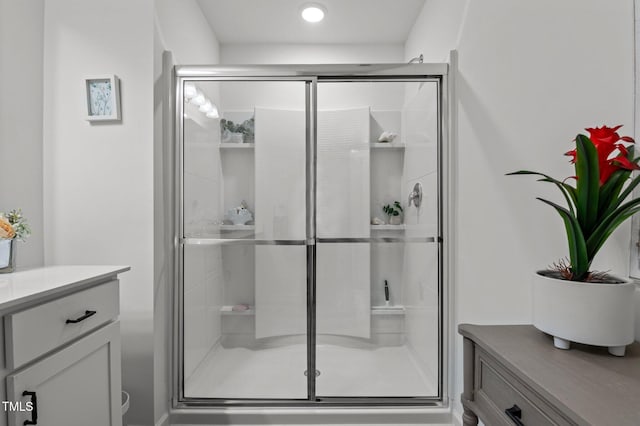 full bath with a shower stall and vanity