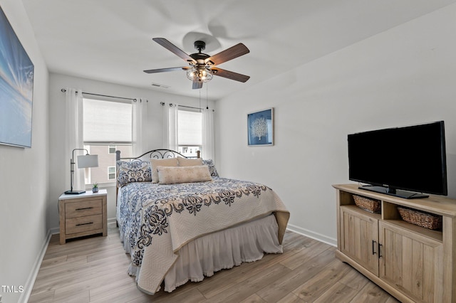 bedroom with a ceiling fan, visible vents, light wood-style flooring, and baseboards