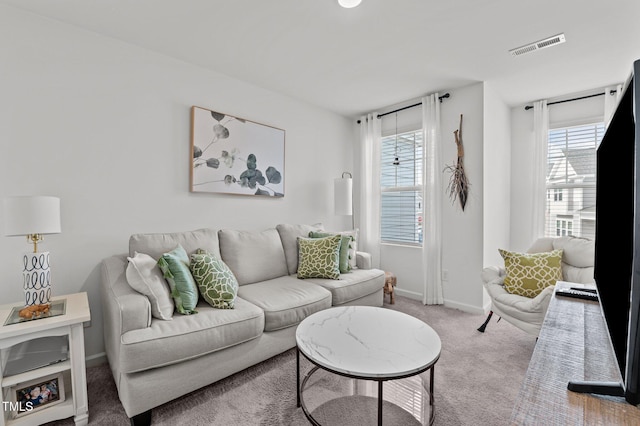 living room featuring carpet floors, visible vents, and baseboards