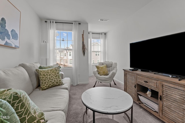 living area with light carpet, visible vents, and baseboards