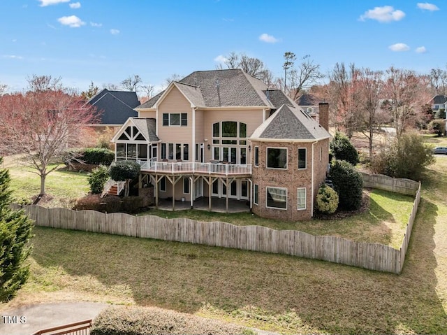 back of property with a deck, fence private yard, stairs, a lawn, and a chimney