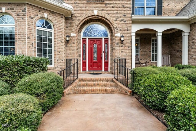 view of exterior entry featuring brick siding