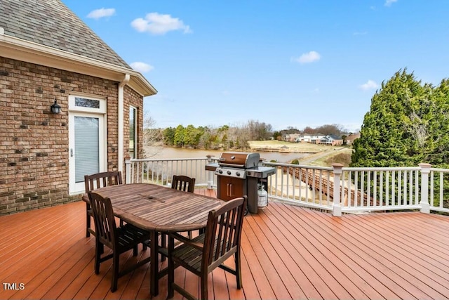 wooden terrace with a water view and outdoor dining area