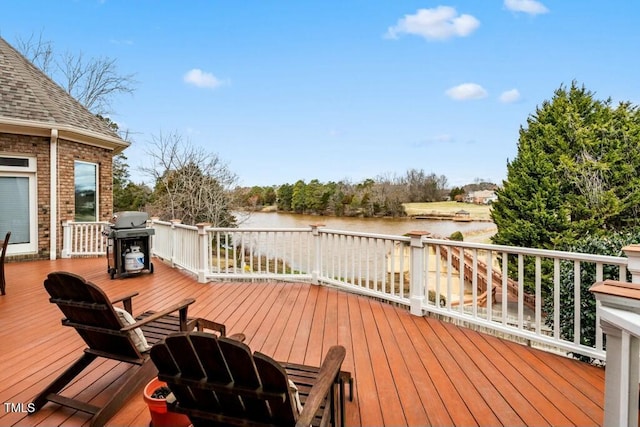 wooden deck with a water view and grilling area