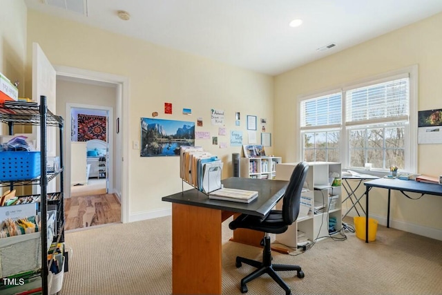 home office with light carpet, visible vents, and baseboards