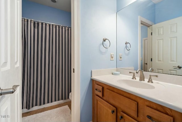 bathroom with toilet, a shower with shower curtain, and vanity