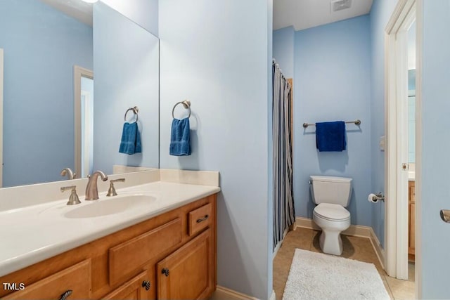 bathroom featuring toilet, visible vents, baseboards, vanity, and tile patterned floors