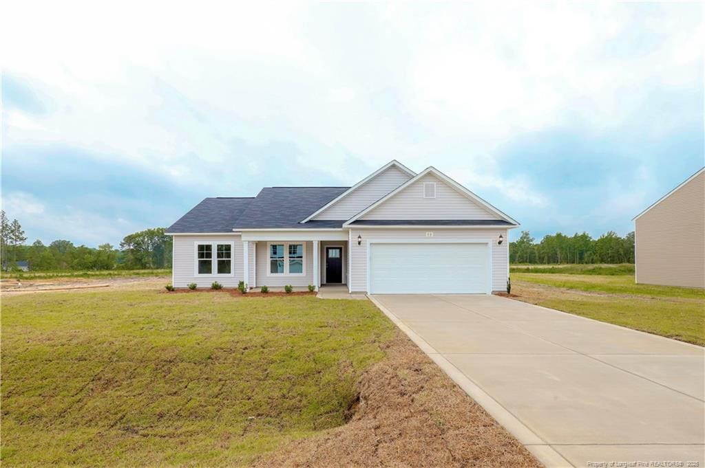 view of front facade featuring a garage, driveway, and a front lawn