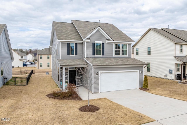 traditional home featuring concrete driveway, roof with shingles, fence, and an attached garage