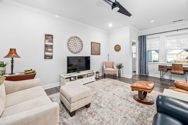 living room featuring baseboards, visible vents, ornamental molding, and wood finished floors