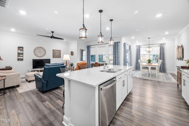 kitchen featuring crown molding, light countertops, open floor plan, a sink, and dishwasher