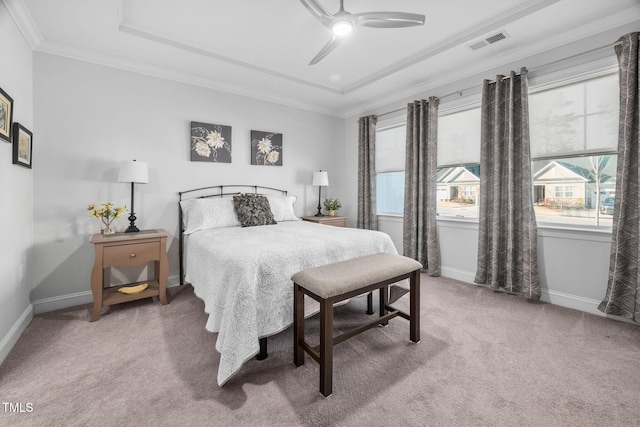 carpeted bedroom featuring baseboards, visible vents, a raised ceiling, ceiling fan, and ornamental molding