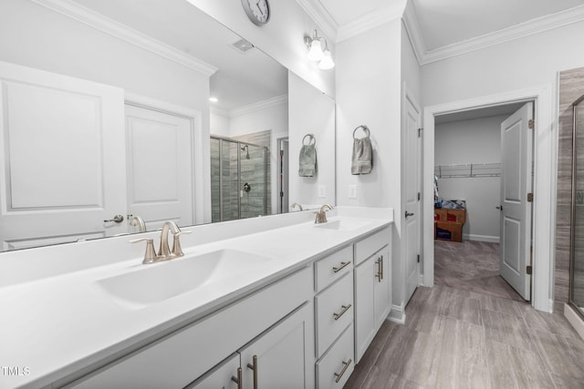 full bathroom featuring crown molding, a stall shower, and a sink