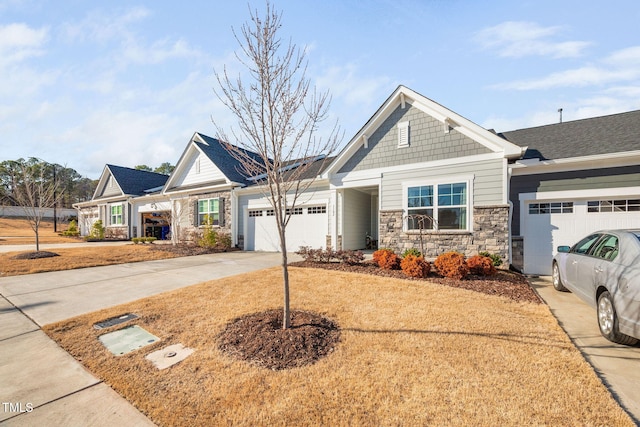 craftsman-style house featuring a garage, stone siding, and driveway