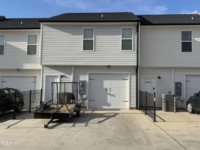 exterior space with a garage, concrete driveway, and central AC