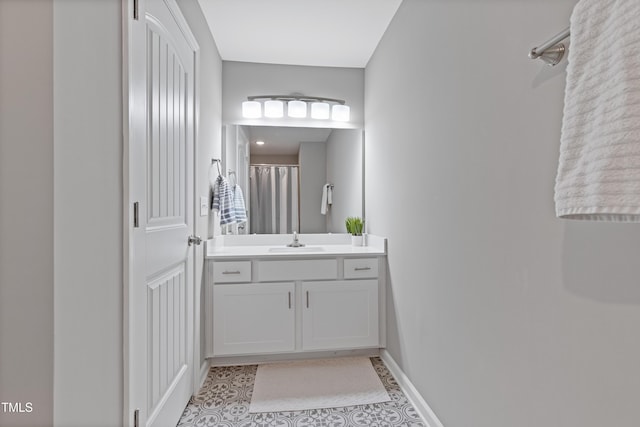 bathroom with vanity, baseboards, and tile patterned floors