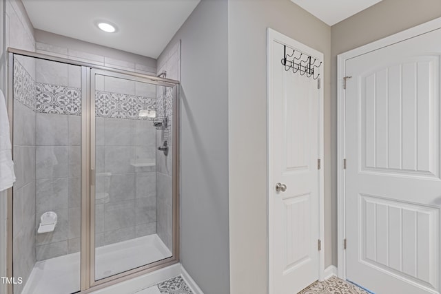 full bath with a shower stall and baseboards