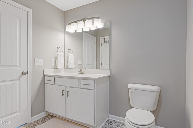 bathroom with baseboards, vanity, and toilet