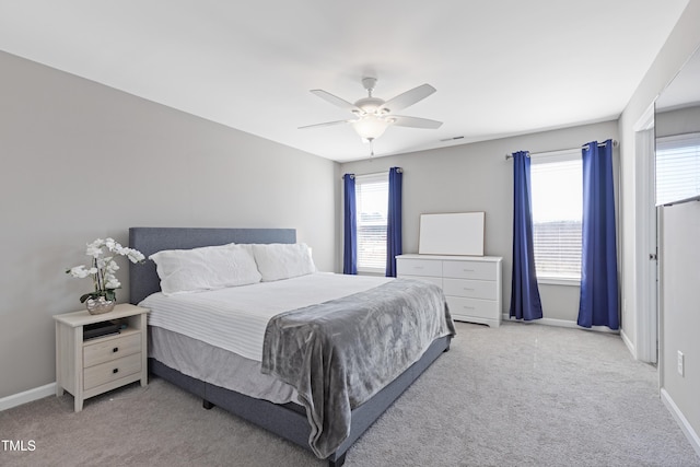 bedroom featuring light carpet, baseboards, and multiple windows