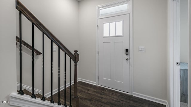 entrance foyer with stairs, dark wood-type flooring, and baseboards