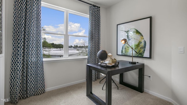 carpeted office space featuring baseboards