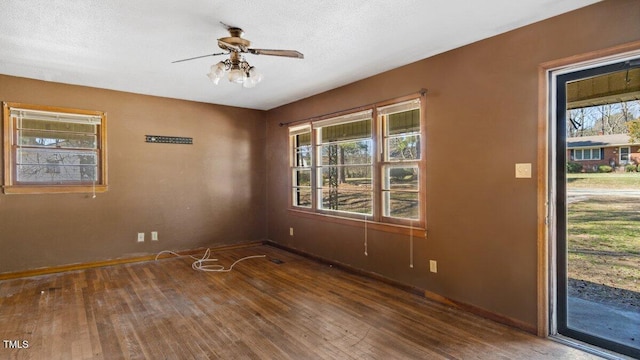 unfurnished room with baseboards, a textured ceiling, a ceiling fan, and hardwood / wood-style floors