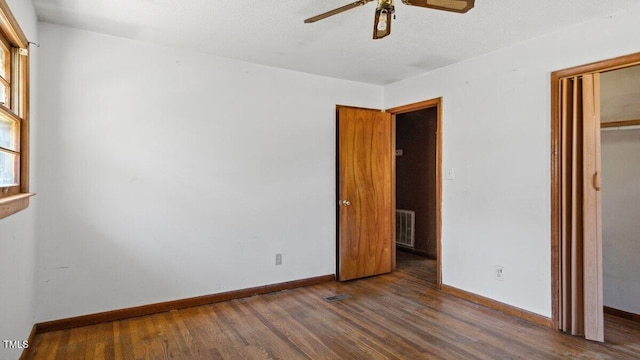 unfurnished bedroom featuring visible vents, baseboards, a ceiling fan, wood finished floors, and a closet