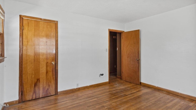 unfurnished room featuring wood finished floors and baseboards