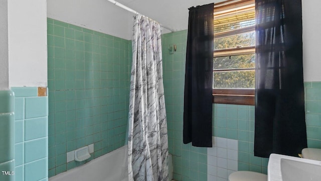 full bath featuring toilet, shower / bath combo, and tile walls