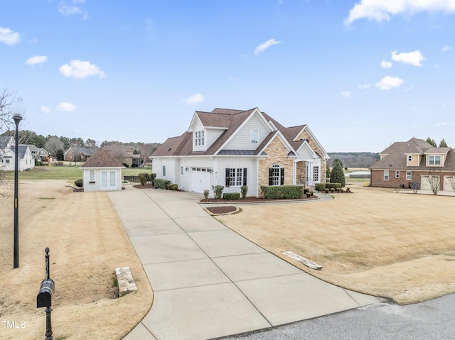 view of front of house with driveway, stone siding, a garage, and a standing seam roof