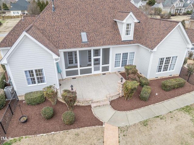 back of house featuring a shingled roof, crawl space, a patio area, a sunroom, and a fenced backyard