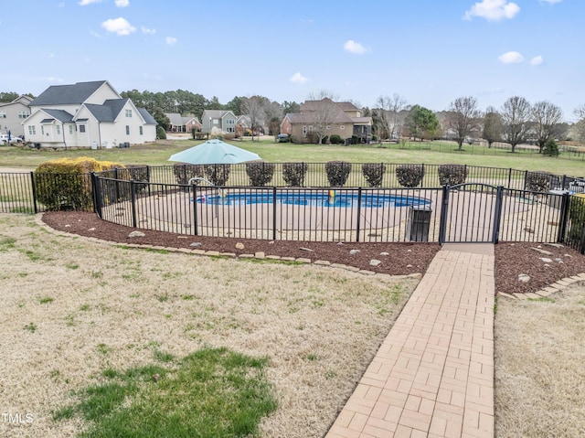 view of pool featuring a lawn, a residential view, fence, and a fenced in pool