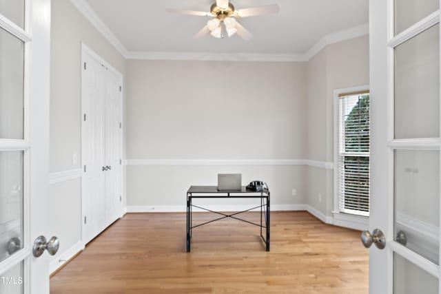 office space with light wood-style floors, crown molding, baseboards, and a ceiling fan