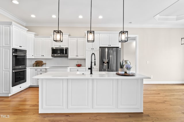 kitchen featuring appliances with stainless steel finishes, light countertops, a sink, and ornamental molding