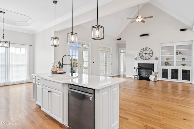 kitchen with french doors, crown molding, a glass covered fireplace, a sink, and light wood-type flooring