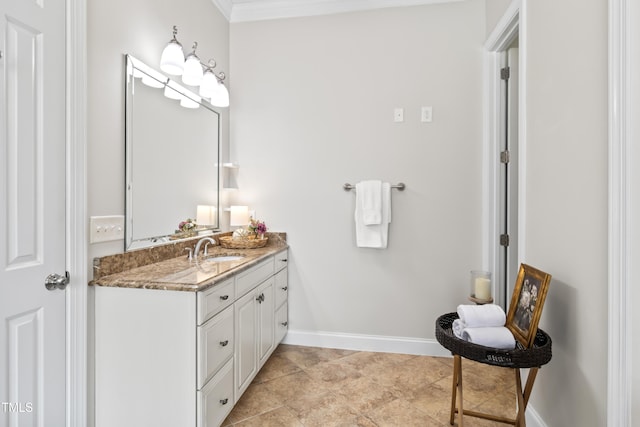 bathroom featuring baseboards, crown molding, and vanity