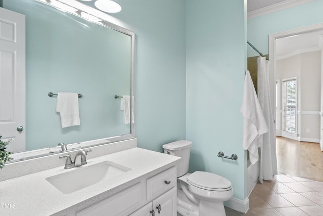 bathroom featuring toilet, vanity, baseboards, ornamental molding, and tile patterned floors